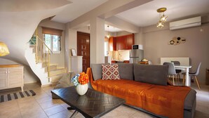 Uma sala de estar moderna com sofá, mesa de centro e escada.
