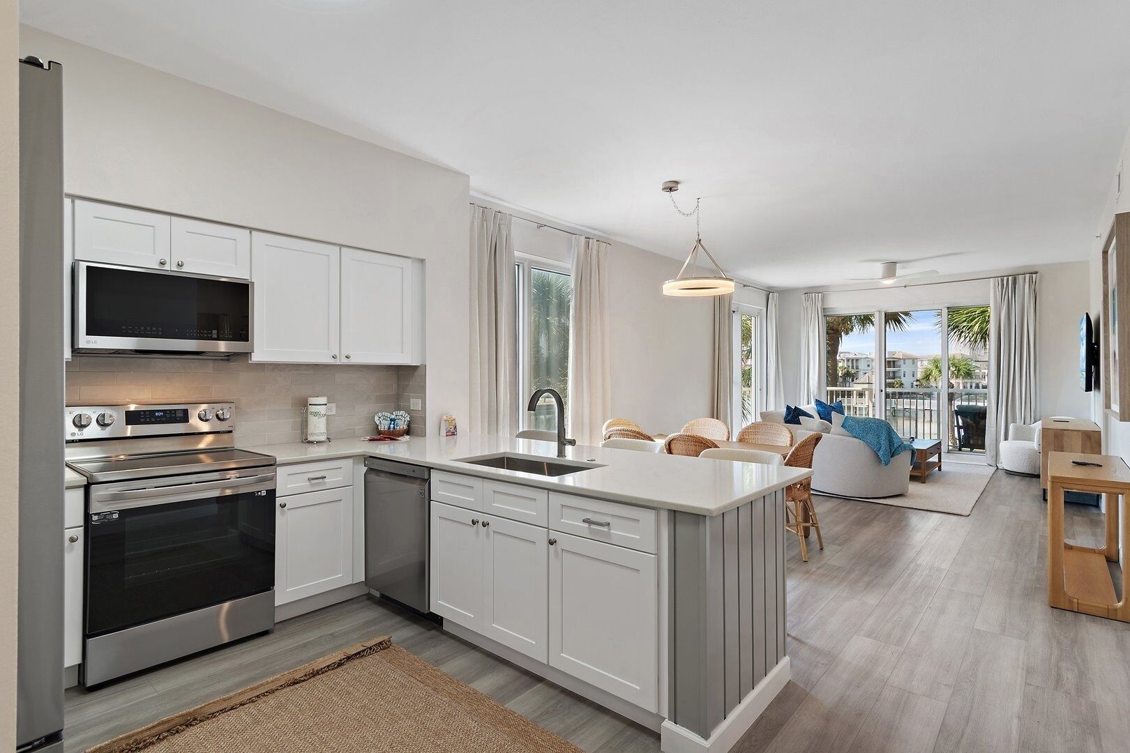 A modern kitchen with white cabinetry, stainless steel appliances, and a central island.