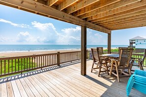 Een houten terras met uitzicht op het strand en de oceaan.