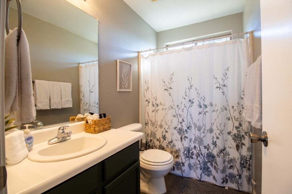 Une salle de bain avec un lavabo, un miroir et des toilettes.