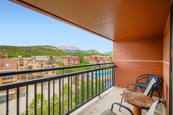Ein Balkon mit Blick auf ein Feriengebiet, einschließlich Gebäude und einem Berg im Hintergrund.