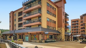 A multi-story hotel with balconies, a covered outdoor area with seating, and a restaurant named "SAUCE." - Village At Breck Antero 1504 1 Bedroom Condo (Breckenridge)