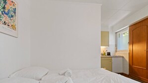 A hotel room with a bed, a small kitchenette, and a wooden wardrobe. - Crans-Montana - Studio ski 2 pers - 3 min Cry d'Er (Crans-Montana)
