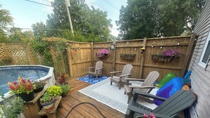 A wooden deck with a hot tub, two Adirondack chairs, a small pool, and potted plants. - Charming 4 Bedroom, Fire Pit, Outdoor Projector, Heated Pool, Close to Downtown (Washington)