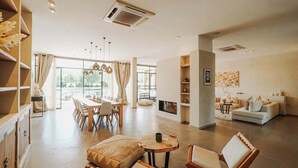Amplia sala de estar con mesa de comedor, sofás y chimenea.