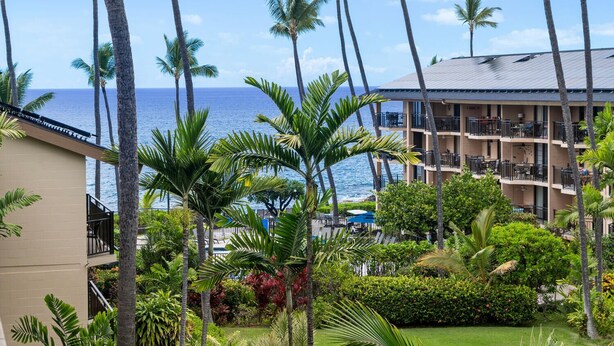 Ein Hotel mit mehreren Balkonen mit Blick auf einen Strand und das Meer.