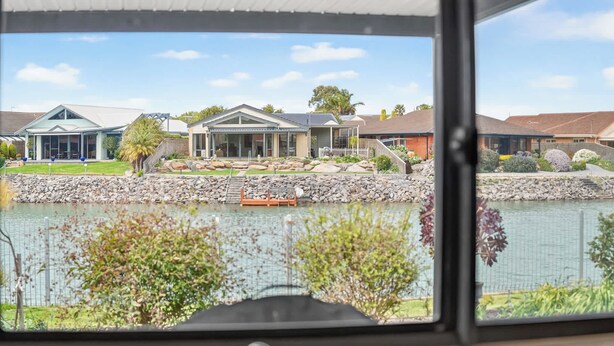 A residential area with a lake, houses, and a boat dock. - 17 Matthew Flinders Dve Encounter Bay (Encounter Bay)