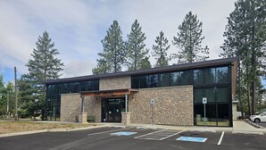 A modern building with a stone facade and large glass windows, labeled "LIBRARY."