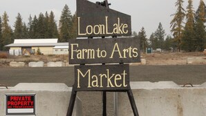 A sign for Loon Lake Farm to Arts Market with a 'Private Property No Trespassing' sign below it.