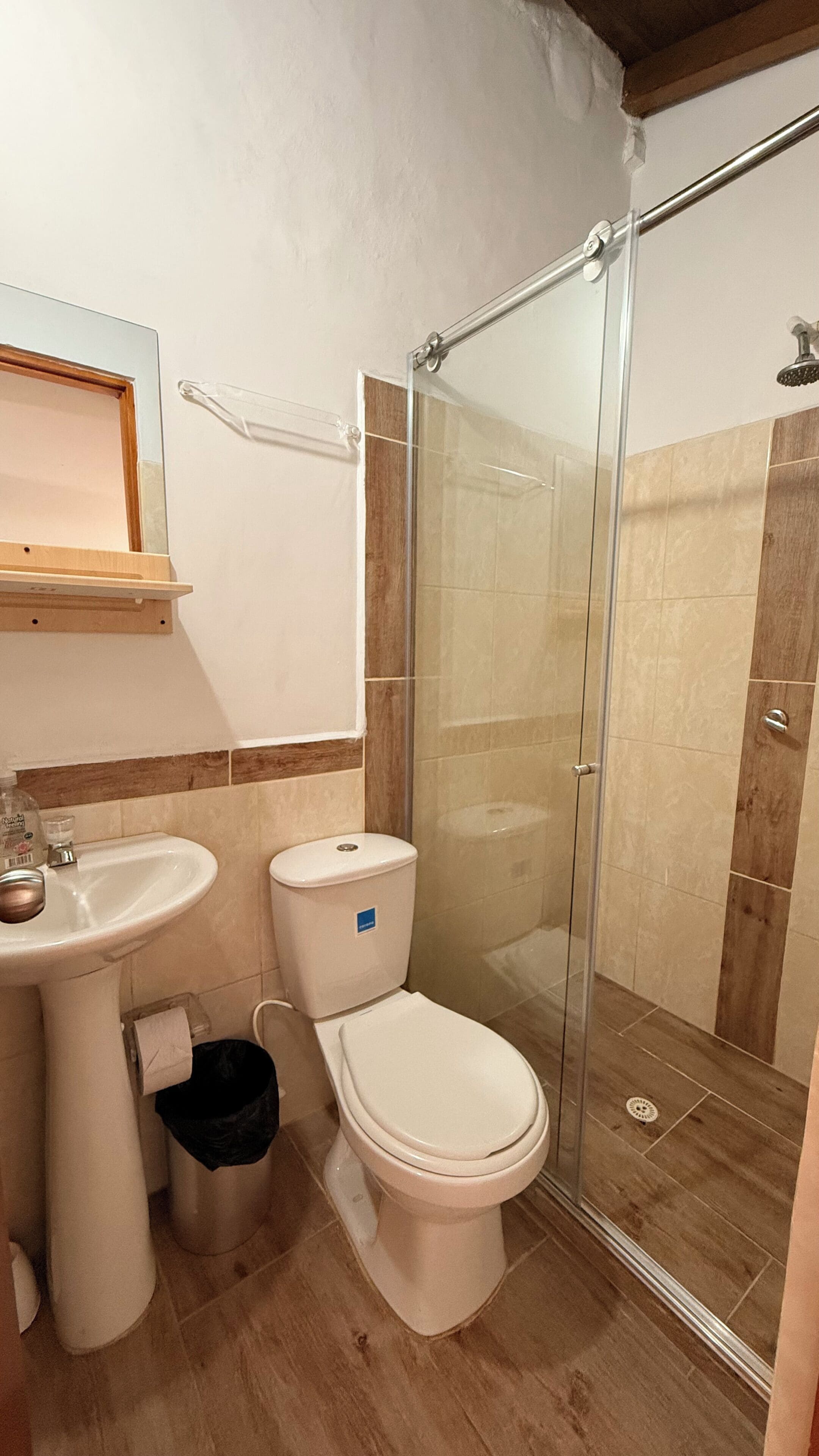 A bathroom with a shower, sink, and toilet.