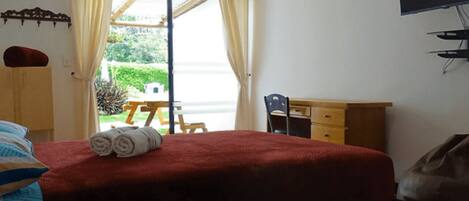 A bedroom with a bed, a desk, and a chair.