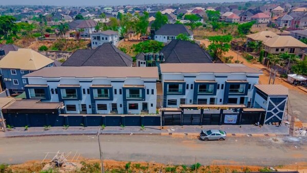 A modern multi-story residential building with a flat roof, large windows, and a garage. - Aviv Luxury Homes (Enugu)