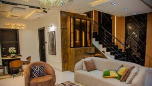 Una sala de estar moderna con sofá, sillón y escalera.