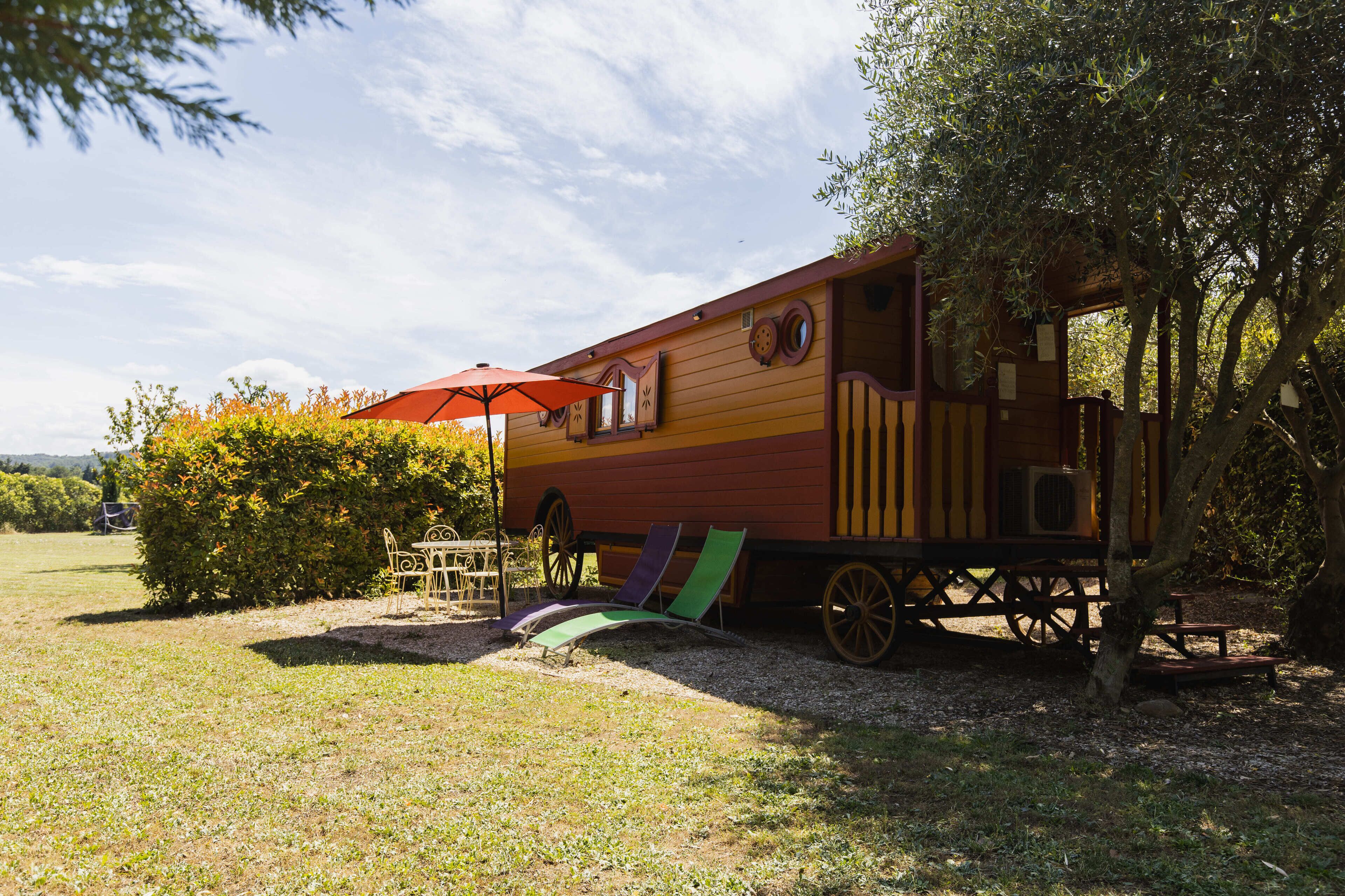 Una estructura de madera con comedor y zona de estar cubierta.