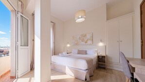 A bedroom with a bed, bedside tables, a desk, and a city view. - Ura Hotel Boutique Gurea (Las Palmas de Gran Canaria)