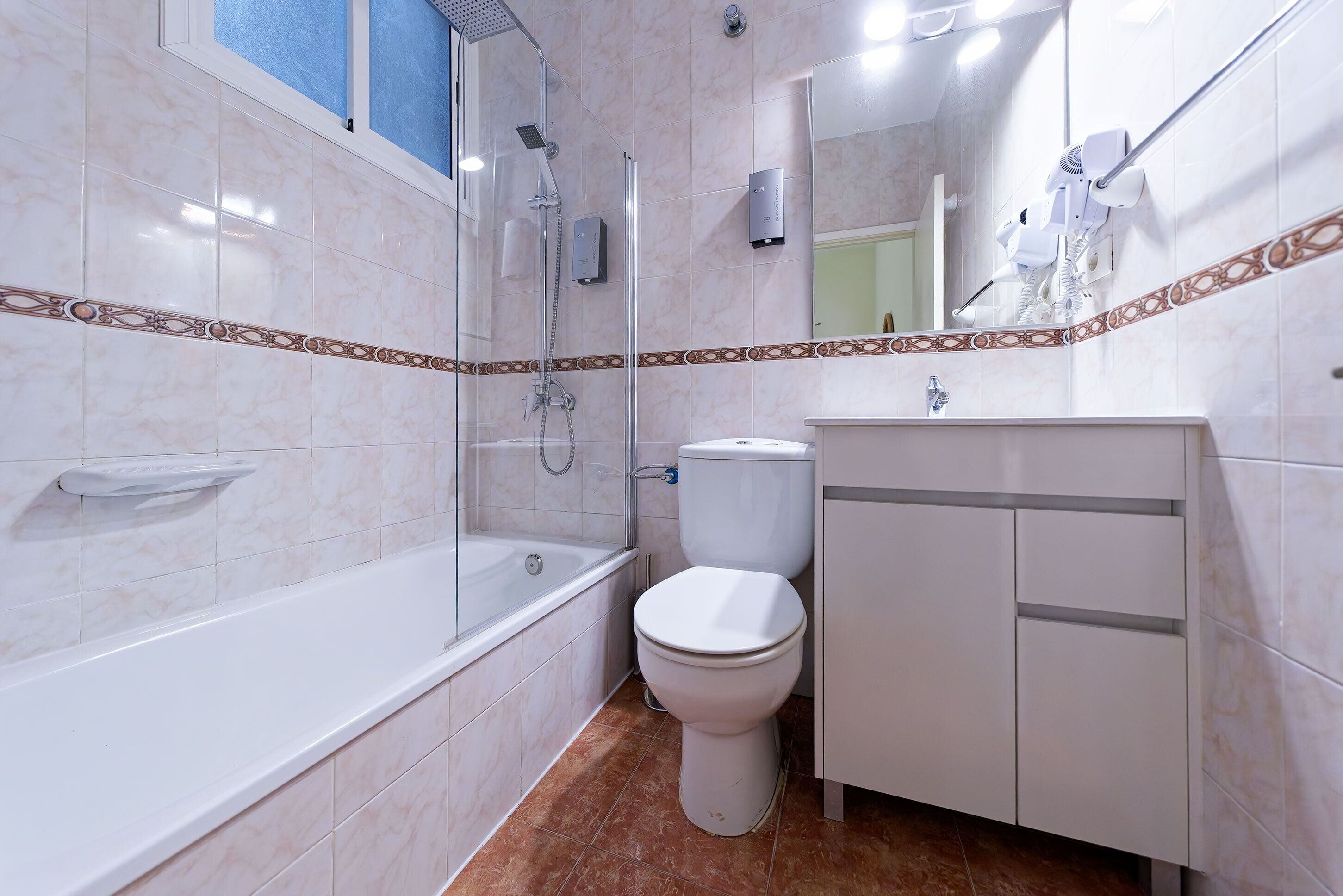 Un baño moderno con bañera, inodoro y zona de ducha.