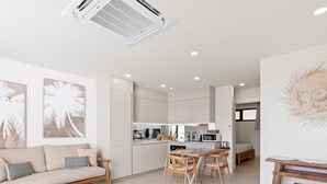 Een modern appartement met een woonkamer, keuken en eethoek.