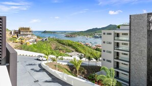 Une vue sur la côte, avec une route, un bâtiment en construction et un immeuble moderne doté de balcons.