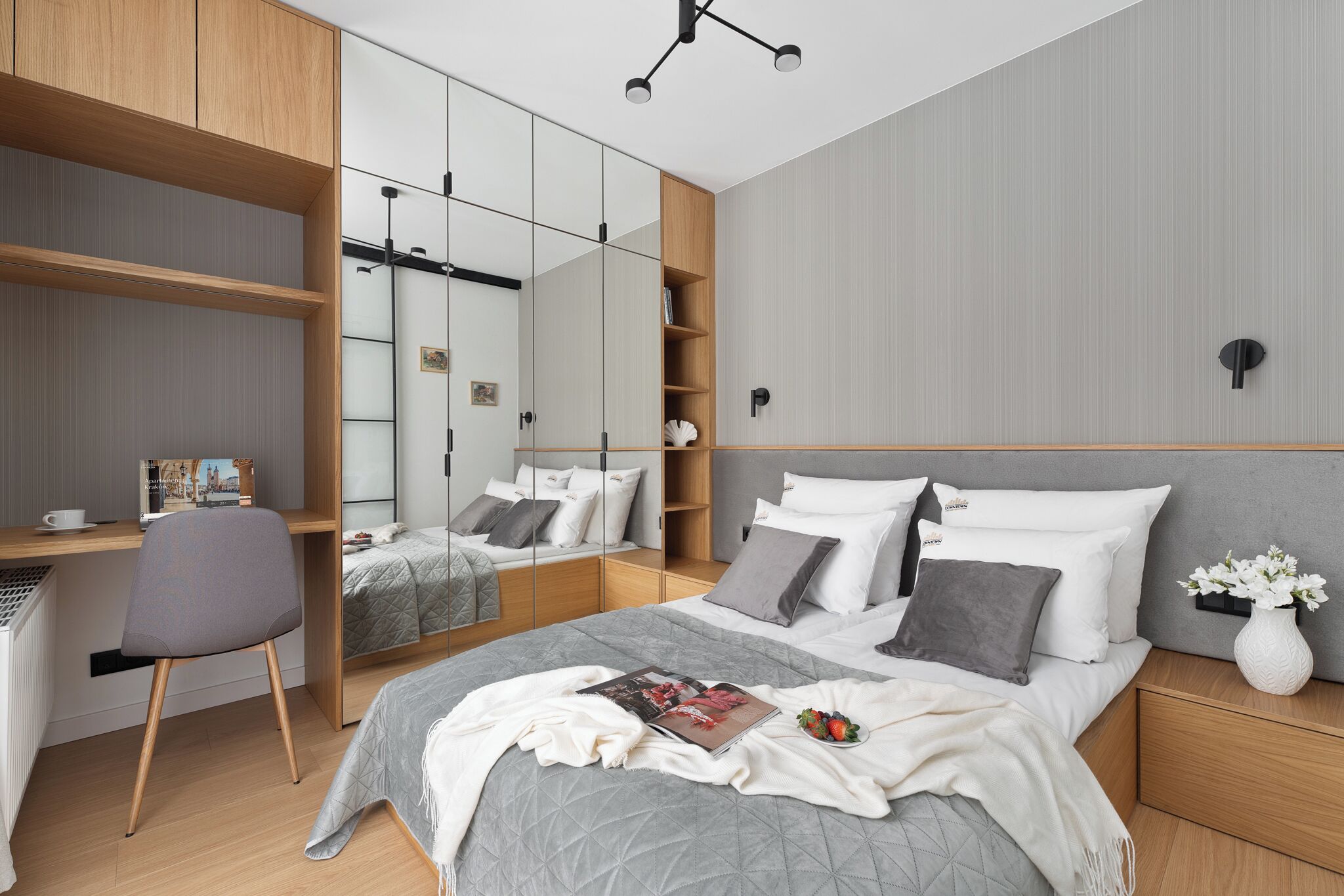 Ein modernes Schlafzimmer mit einem Bett, Nachttischen, einem Schreibtisch und einem Stuhl.