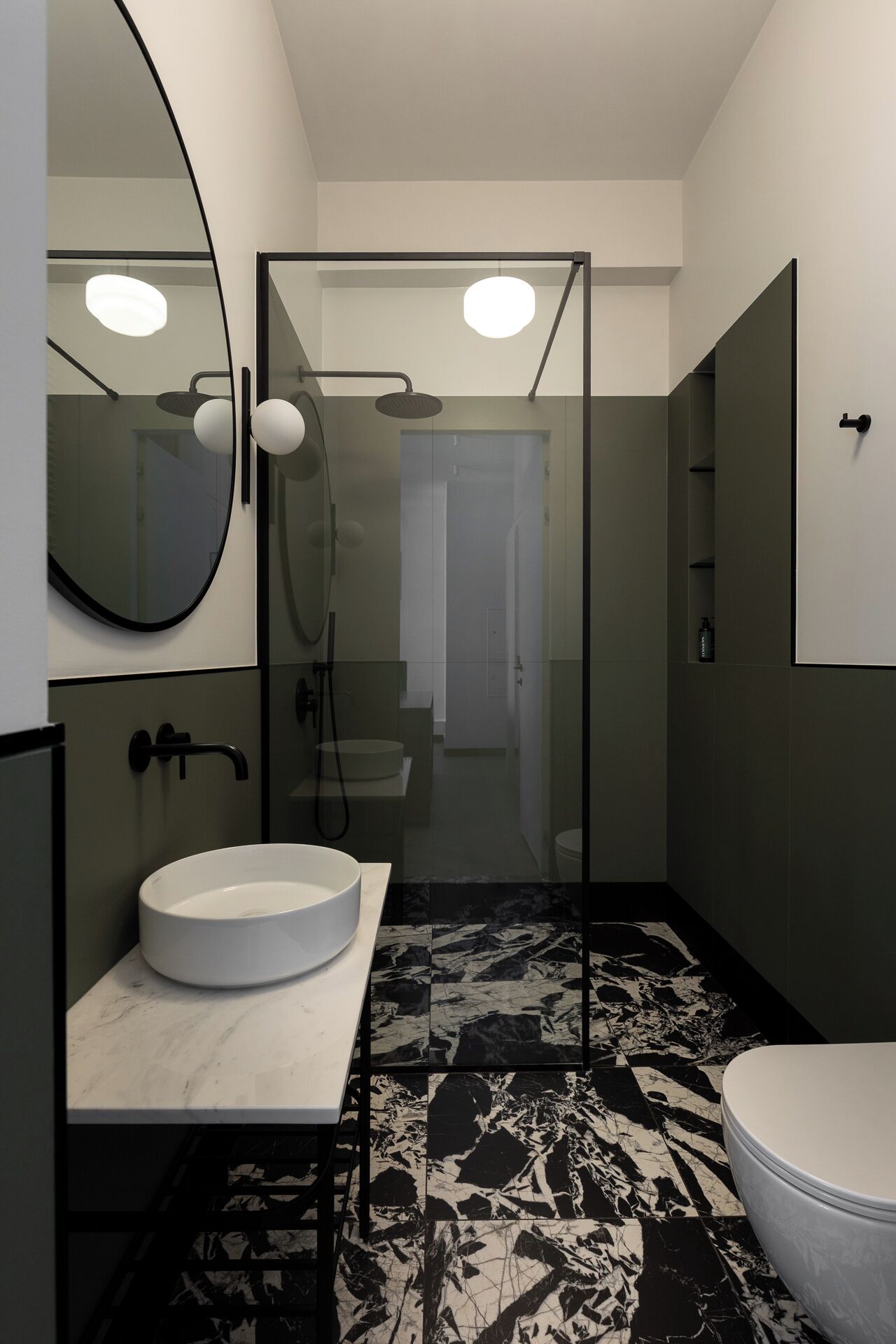 Ein modernes Badezimmer mit einem runden Waschbecken, einer Duschkabine und einer Toilette.