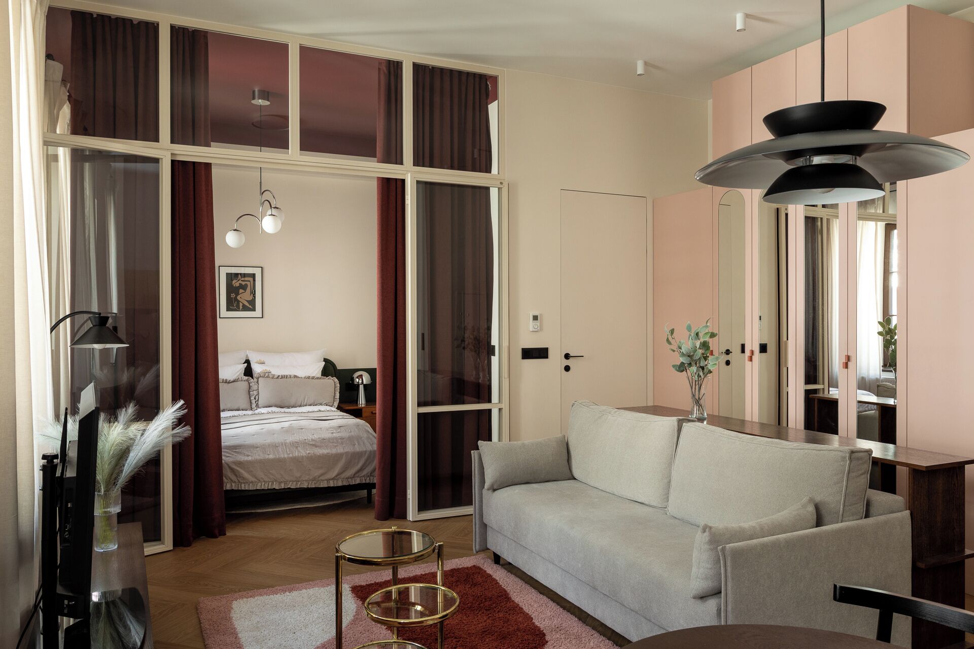 Une chambre moderne avec un lit, un canapé, une télévision et une grande fenêtre avec des rideaux.