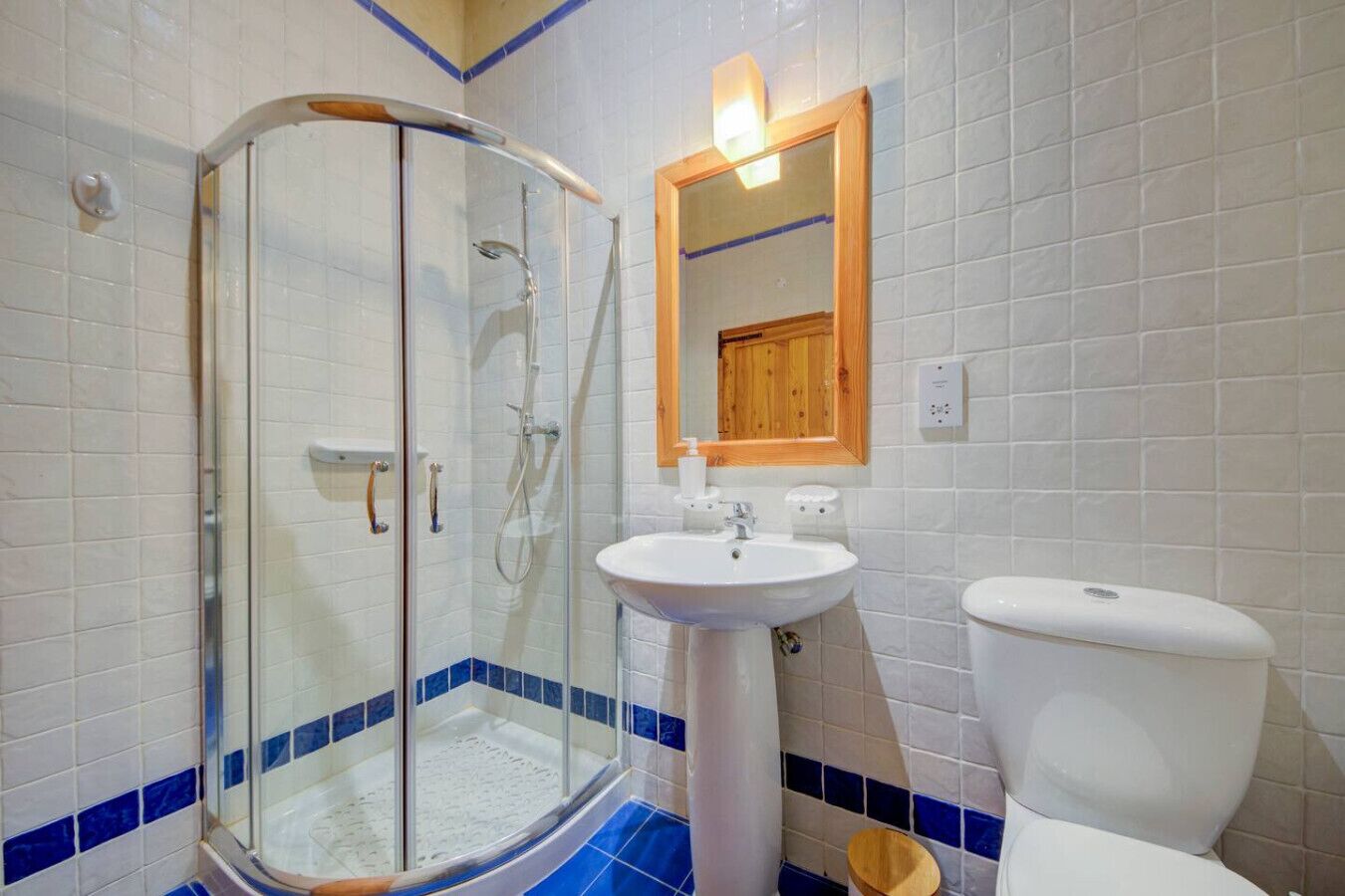 Une salle de bain avec une douche à parois de verre, un lavabo et des toilettes.