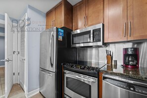 A kitchen with stainless steel appliances, wooden cabinets, and a coffee maker.