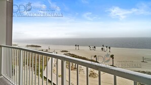 A balcony with a view of a beach and ocean.