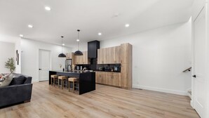 Una cucina moderna con mobili in legno, un'isola centrale e un piano di lavoro nero.
