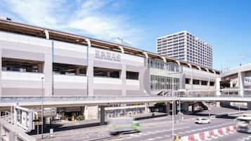 A multi-level parking structure with a pedestrian bridge, overpasses, and a clear sky.