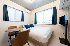 A hotel room with a bed, a TV, a table, and two chairs. - Ferio Kamata II (Tokyo)