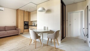 A modern living space with a dining area, a sofa, and a kitchen. - Rodos Arcadia Apartments (Odesa)