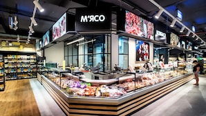 A modern grocery store with a central display of fresh produce and packaged goods. - Rodos Arcadia Apartments (Odesa)