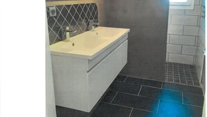 A bathroom with a white sink, a mirror, and a towel rack.