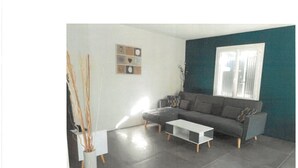 A modern living room with a grey sofa, a white coffee table, and a blue accent wall.