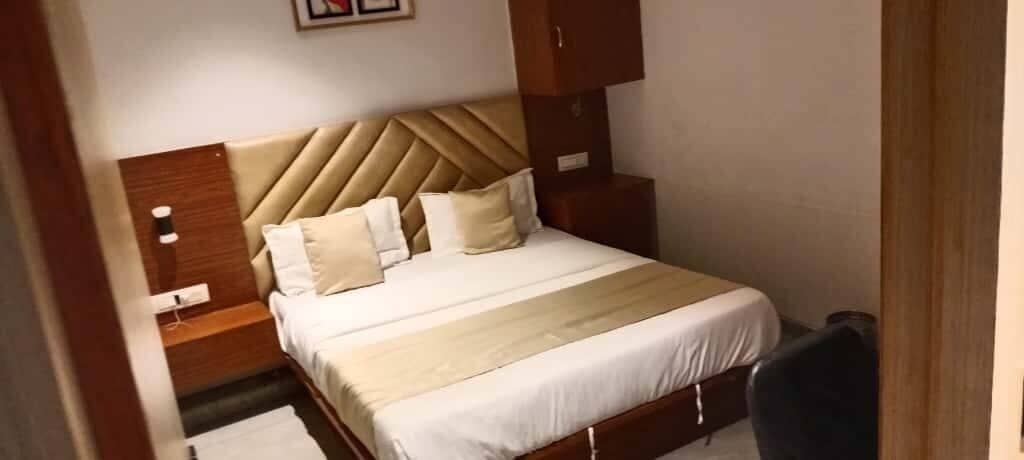 A neatly made bed with a headboard, a bedside table, and a nightstand.