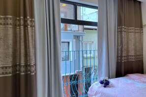 A room with a bed, a window with curtains, and a view of a balcony. - TaksimBlue (Istanbul)