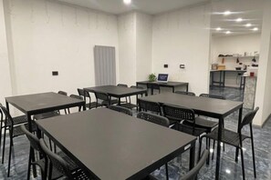 A conference room with multiple tables and chairs, a small kitchenette, and a grey door. - TaksimBlue (Istanbul)