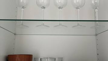 Uno scaffale con bicchieri da vino e tazze.