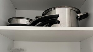 A kitchen shelf with cookware, glassware, and plates. - Bright and lovingly furnished vacation apartment with a feel-good atmosphere (Hamm)