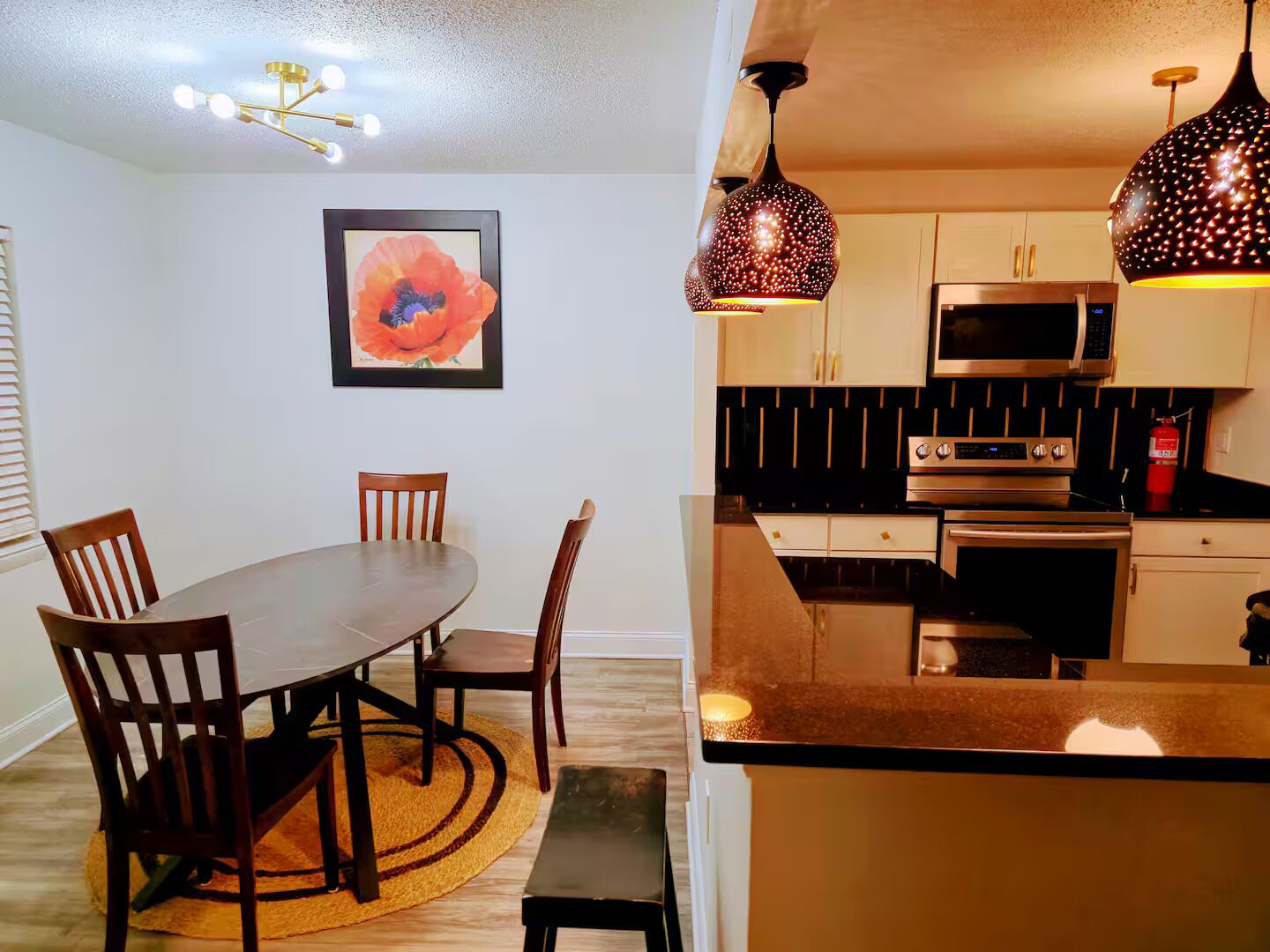 A modern kitchen with a central island, stainless steel appliances, and pendant lighting.