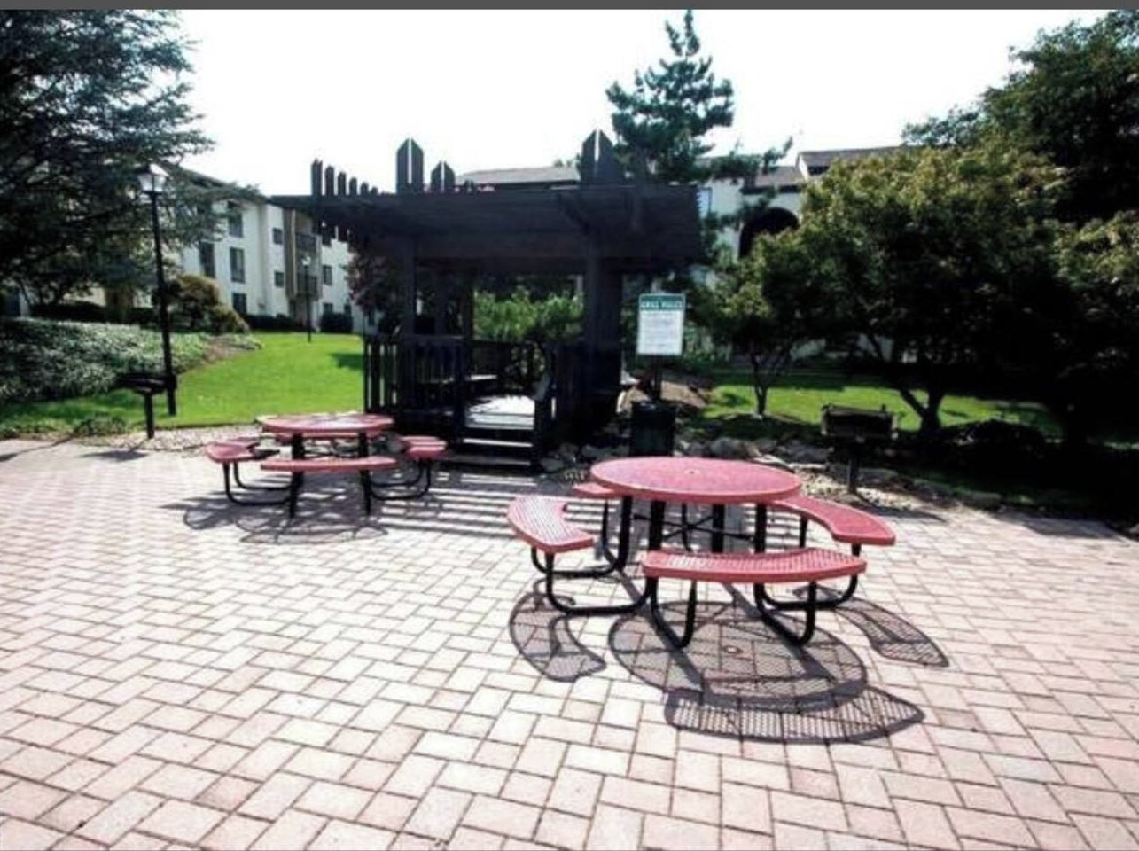 Un área de patio al aire libre con mesas de picnic y un pabellón.
