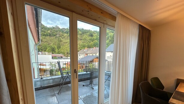 A room with a sliding glass door leading to an outdoor patio area. - Apartment Bergblick | Top vacation apartment with view of mountains and Ahr 1-4 persons (Altenahr)