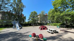 Ein Spielplatz mit Rutschen, Schaukeln und einer Spielkonstruktion zum Thema Insekten.