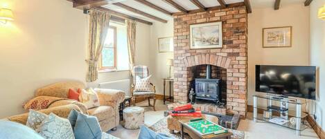 A cozy living room with a fireplace, comfortable seating, and a flat-screen TV.