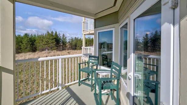 A balcony with a view of a forest and a clear sky. - 2bd, 2ba, Walk to Town and Beach (SRetreat) (Long Beach)
