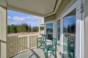 A balcony with a view of a forest and a clear sky.