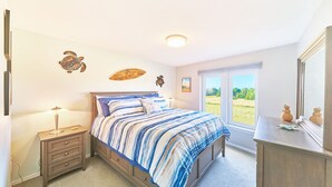 A bedroom with a bed, bedside tables, a dresser, and a window with a view of greenery. - 2bd, 2ba, Walk to Town and Beach (SRetreat) (Long Beach)
