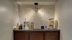 A kitchen with a stone backsplash, a built-in oven, a sink, and a coffee machine.