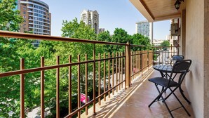 Un balcón con vistas a edificios y árboles de la ciudad.